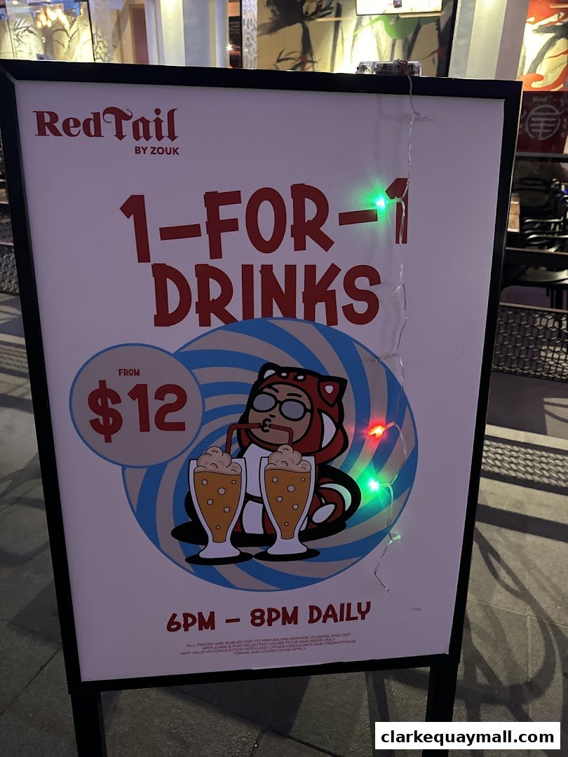 A sign advertising 1-for-1 drinks at RedTail Bar By Zouk from $12.