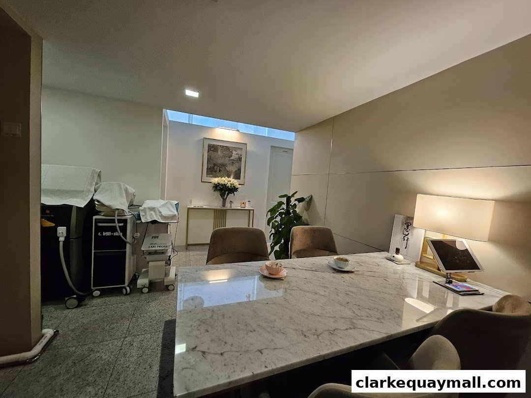 Interior of a modern clinic with treatment machines, comfortable seating, and a marble table.