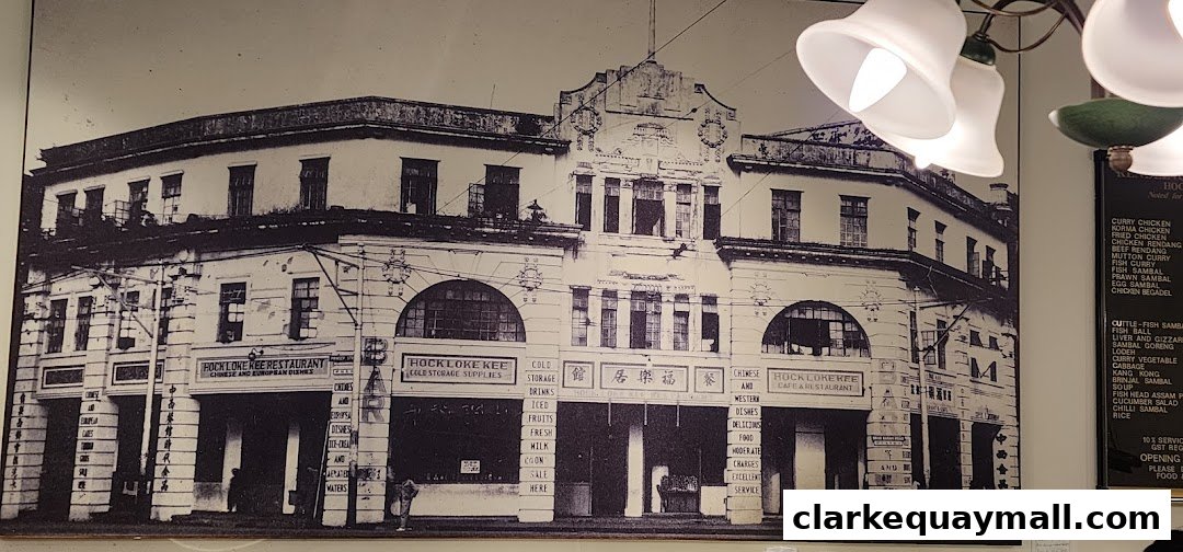 A black and white photograph of a historic building with signage for Rendezvous Restaurant Hock Lock Kee.