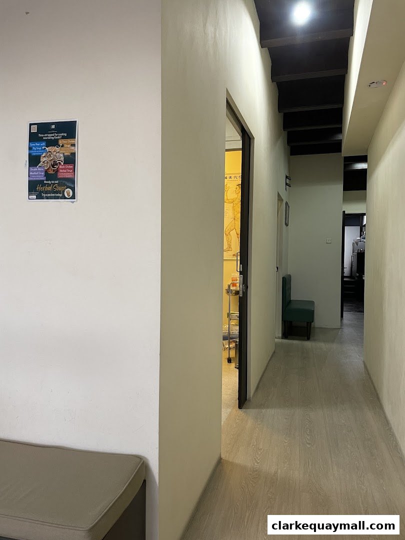 A hallway inside Renhai Clinic with a poster on the wall and an open doorway.