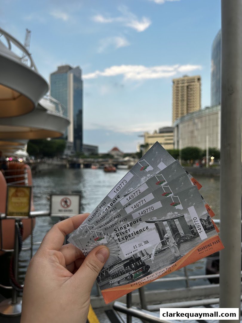 A hand holds several boarding passes for a Singapore River Experience cruise.