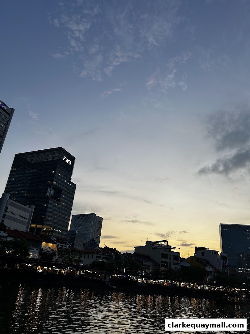 A scenic view of a riverfront with buildings and a sunset sky.