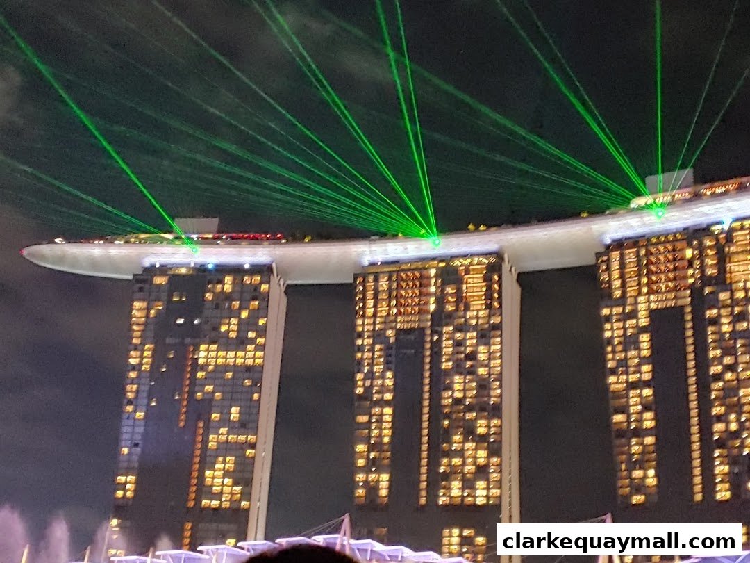 Marina Bay Sands hotel illuminated with green laser lights at night.
