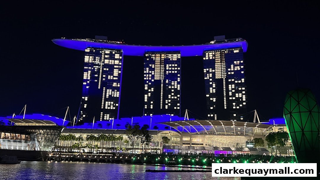 The iconic Marina Bay Sands hotel illuminated at night with blue lights and many windows lit.