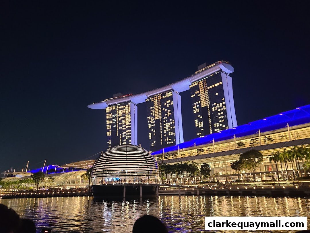 Night view of Marina Bay Sands and the waterfront promenade with illuminated buildings.