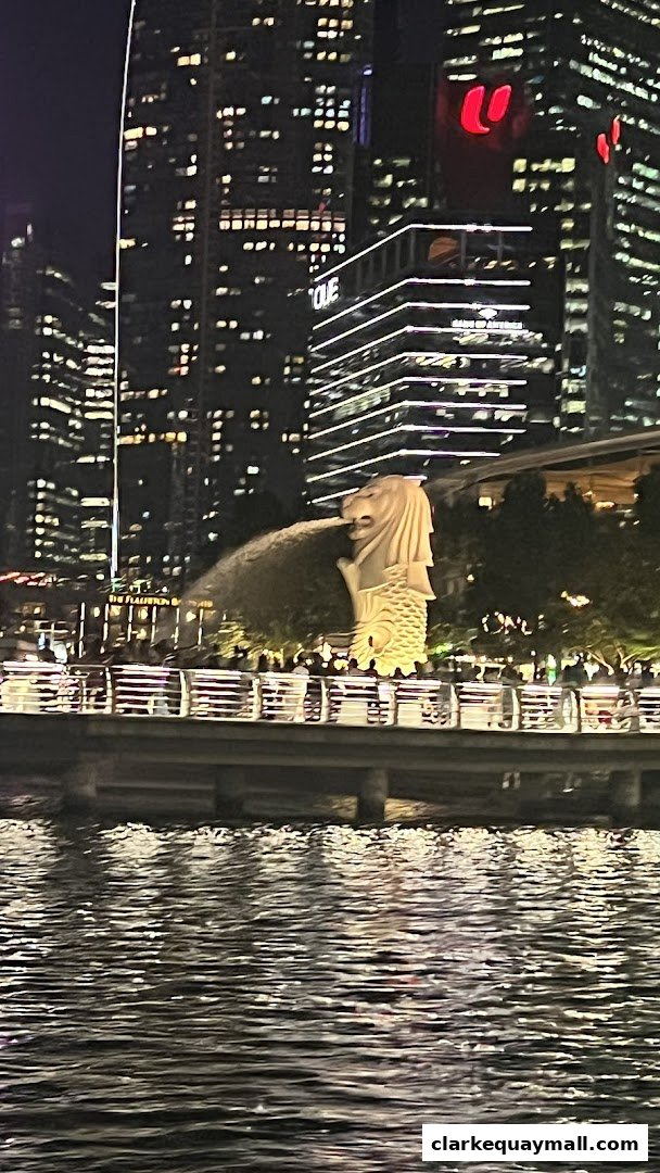 Night view of the Merlion statue with city skyline and water in the foreground.