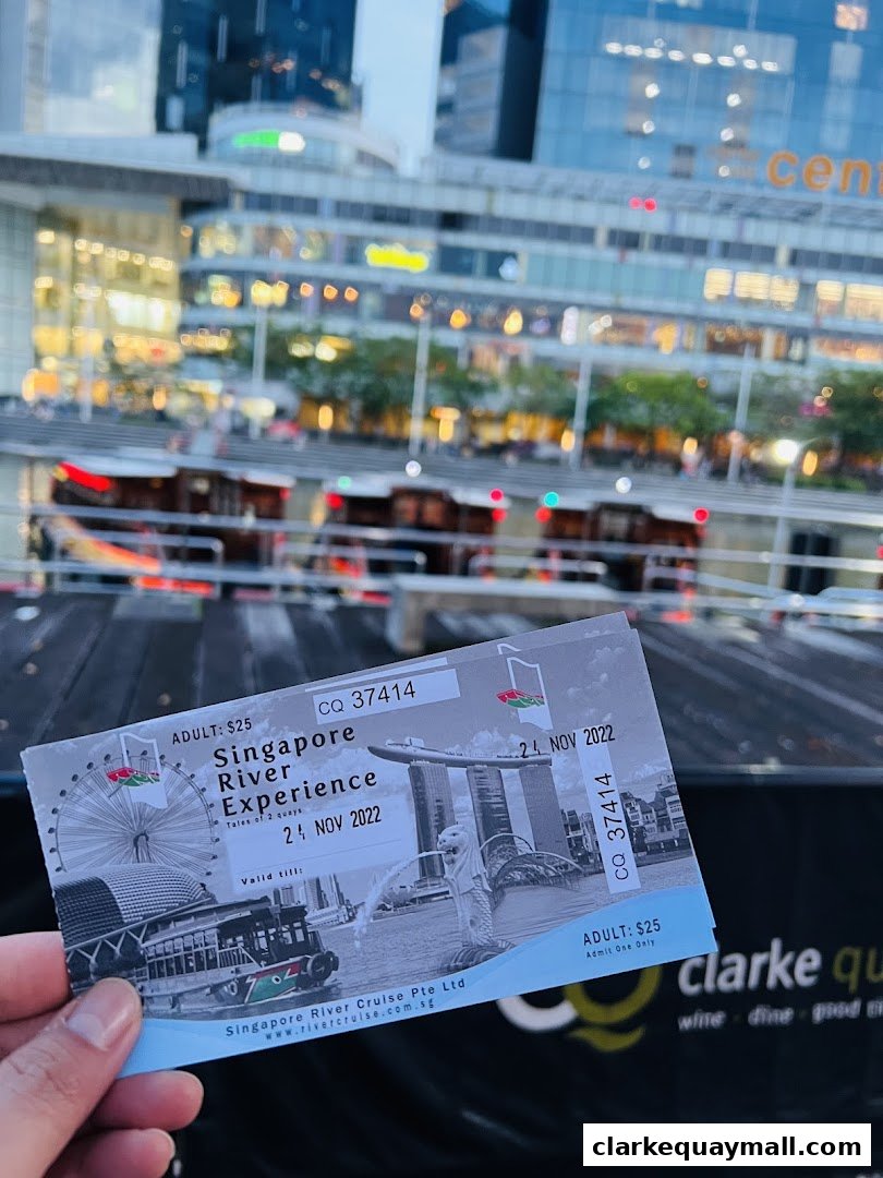 A hand holds a ticket for the Singapore River Experience with city skyline in the background.