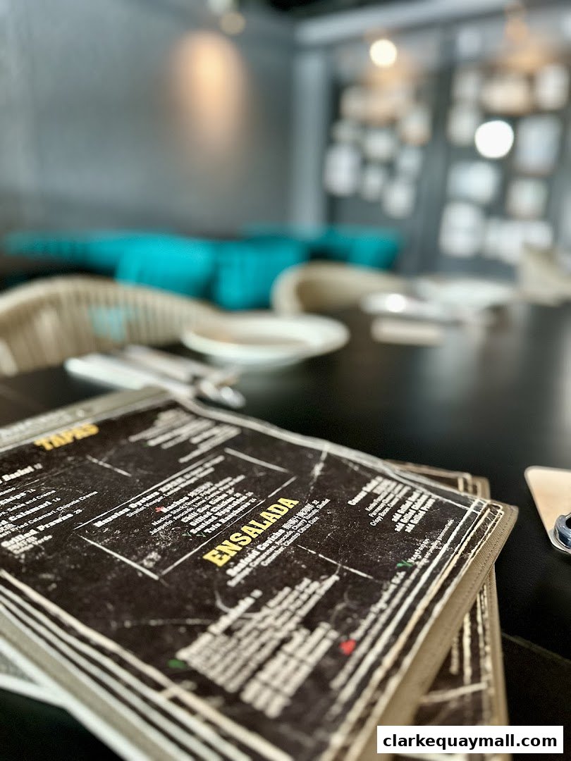 A close-up view of a restaurant menu with tapas and ensalada sections visible.