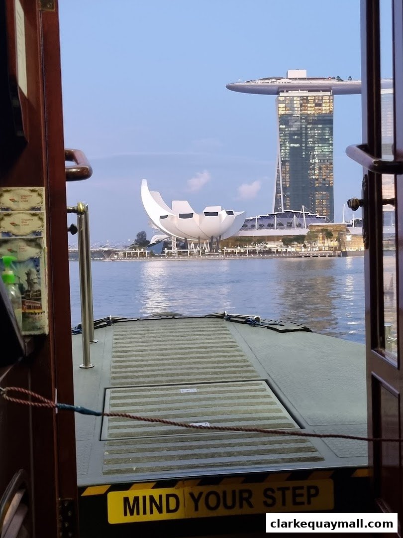 View of Singapore skyline from a boat, with Marina Bay Sands and ArtScience Museum visible.