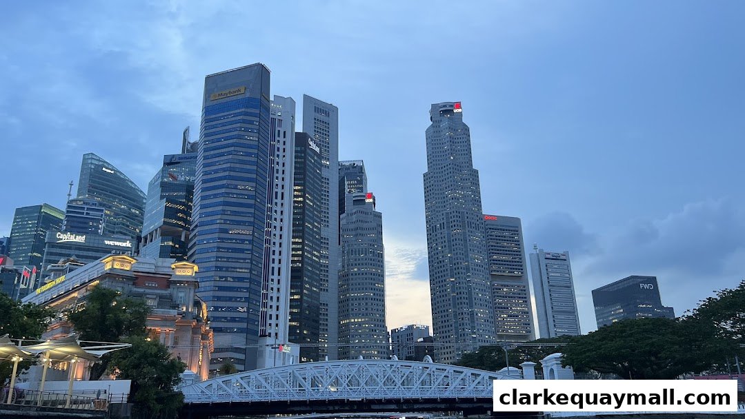 A cityscape view of modern skyscrapers and a bridge over a river at dusk.