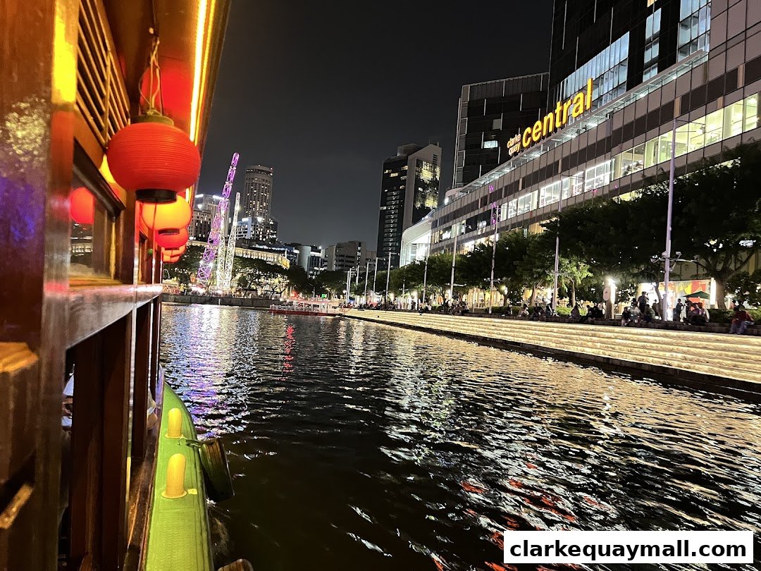 Night view of a river cruise with illuminated buildings and people relaxing by the water.
