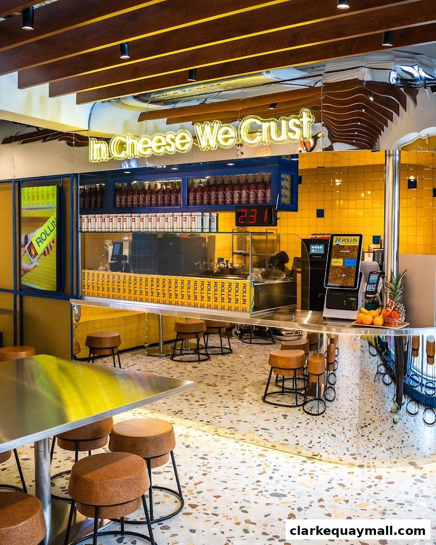 Interior of a modern food stall with yellow tiles, neon sign, and seating.