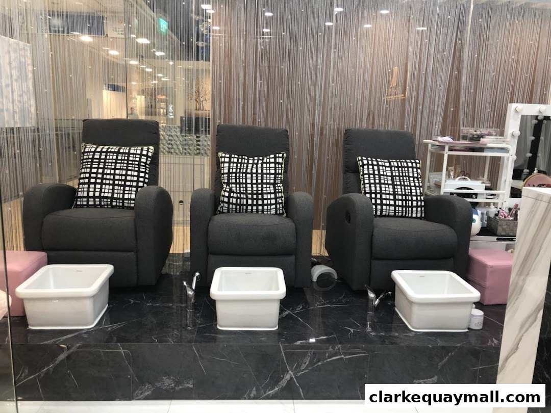 Three comfortable recliners with foot baths set up for pedicures at a nail salon.