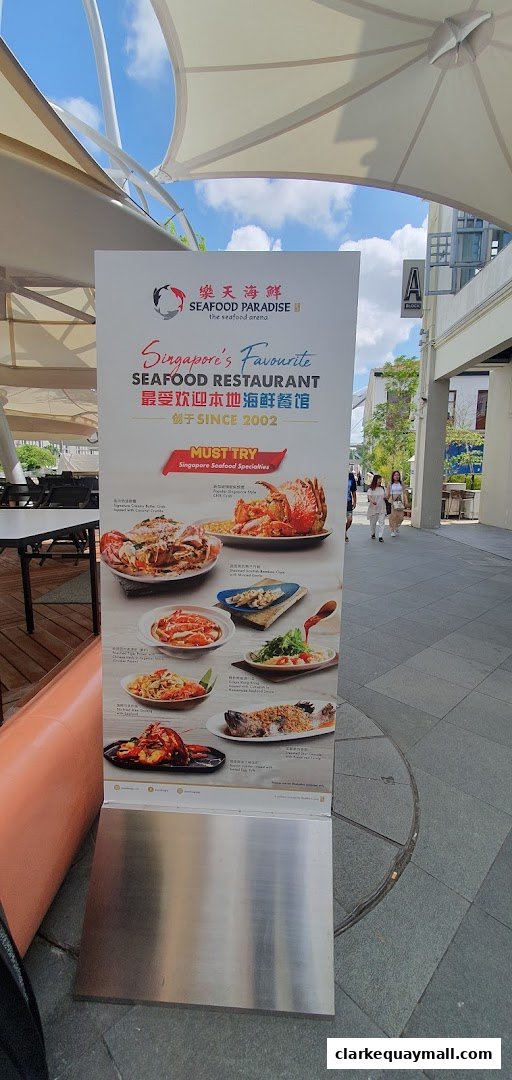 A sign for Seafood Paradise restaurant showcasing popular seafood dishes.