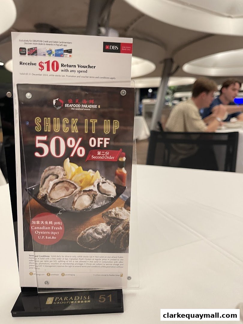 A promotional stand for Seafood Paradise offering 50% off second order of Canadian Fresh Oysters.