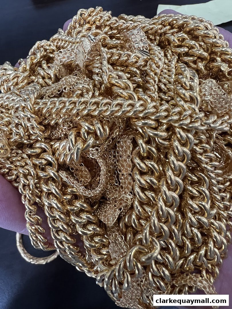 A close-up shot of a large pile of gleaming gold chains and jewelry.