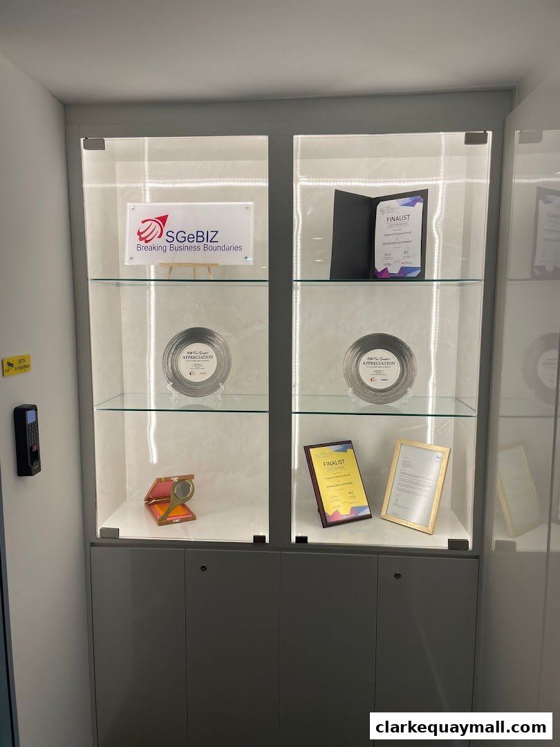 A display cabinet showcasing awards and certificates for Singapore E-Business Pte. Ltd.