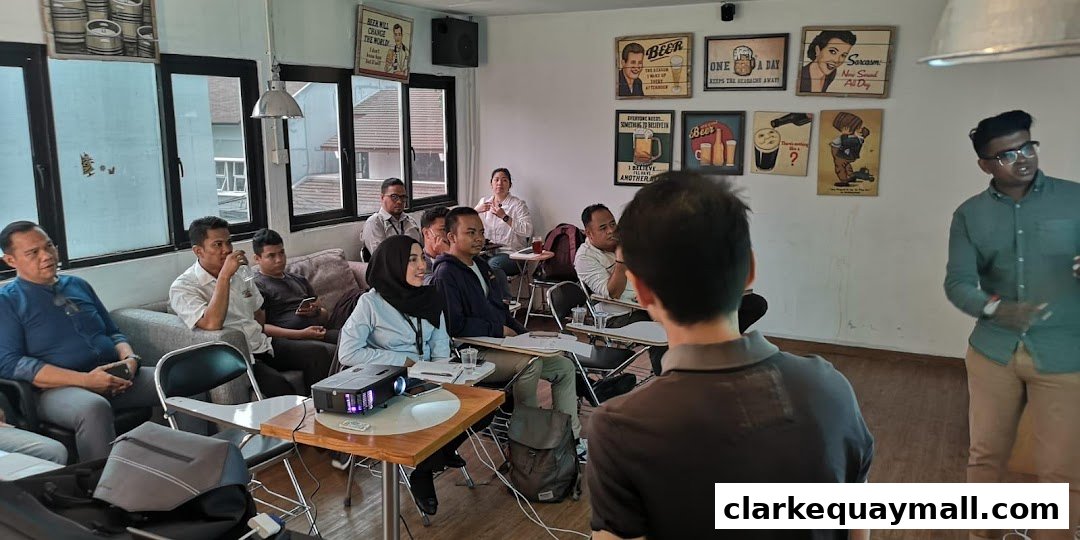 A group of people attending a presentation in a modern office space with decorative posters.
