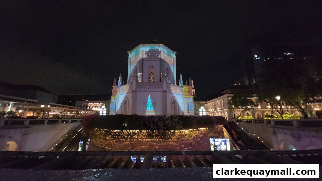 A building illuminated with colorful projections at night, with surrounding architecture and lights.