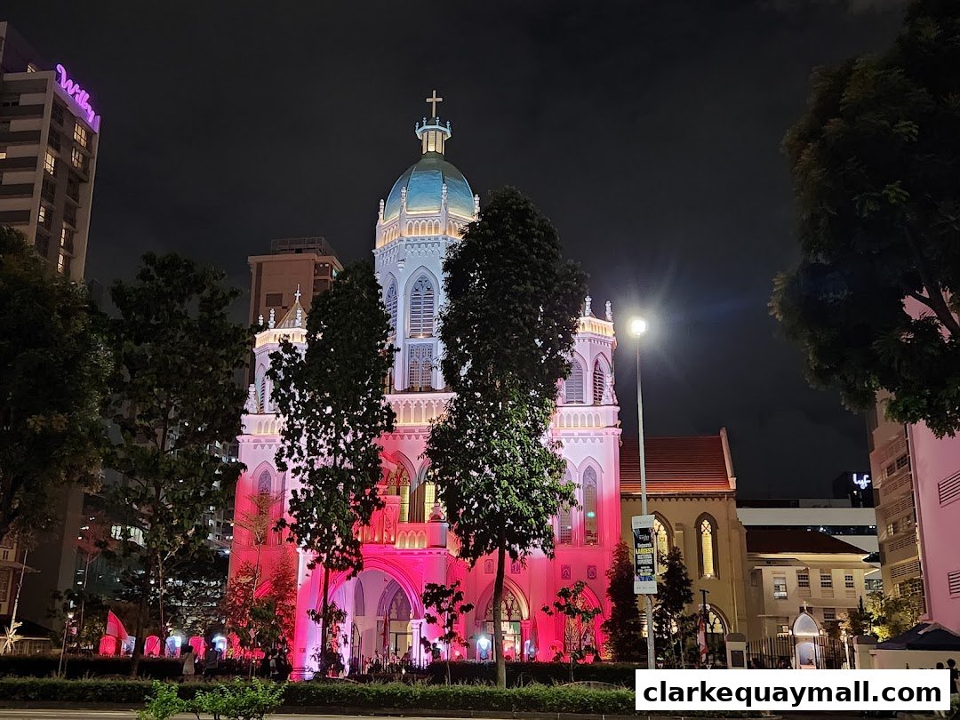 A beautifully illuminated church at night, with vibrant pink and blue lights highlighting its architecture.