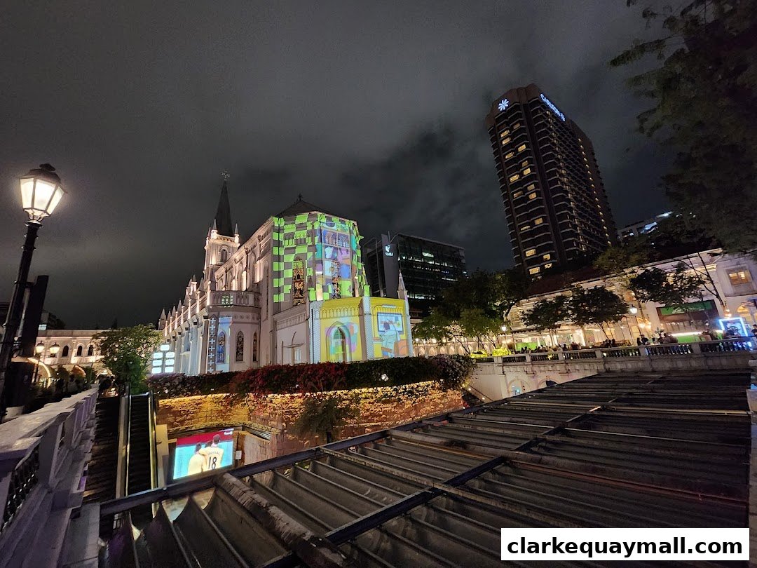 A beautifully lit building with projected patterns at night, overlooking a bustling street.