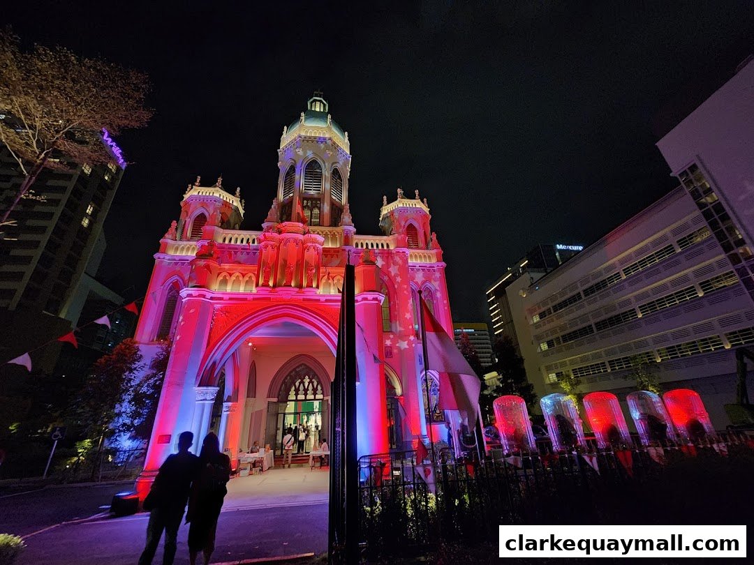 A beautifully illuminated building at night, with people standing in front.