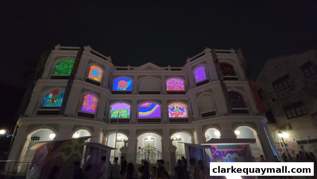 A building facade illuminated with colorful art projections at night, with people gathered below.