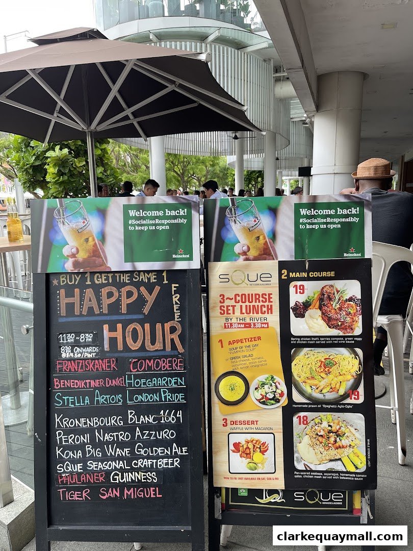 A sidewalk chalkboard and display advertising happy hour specials and a 3-course lunch.