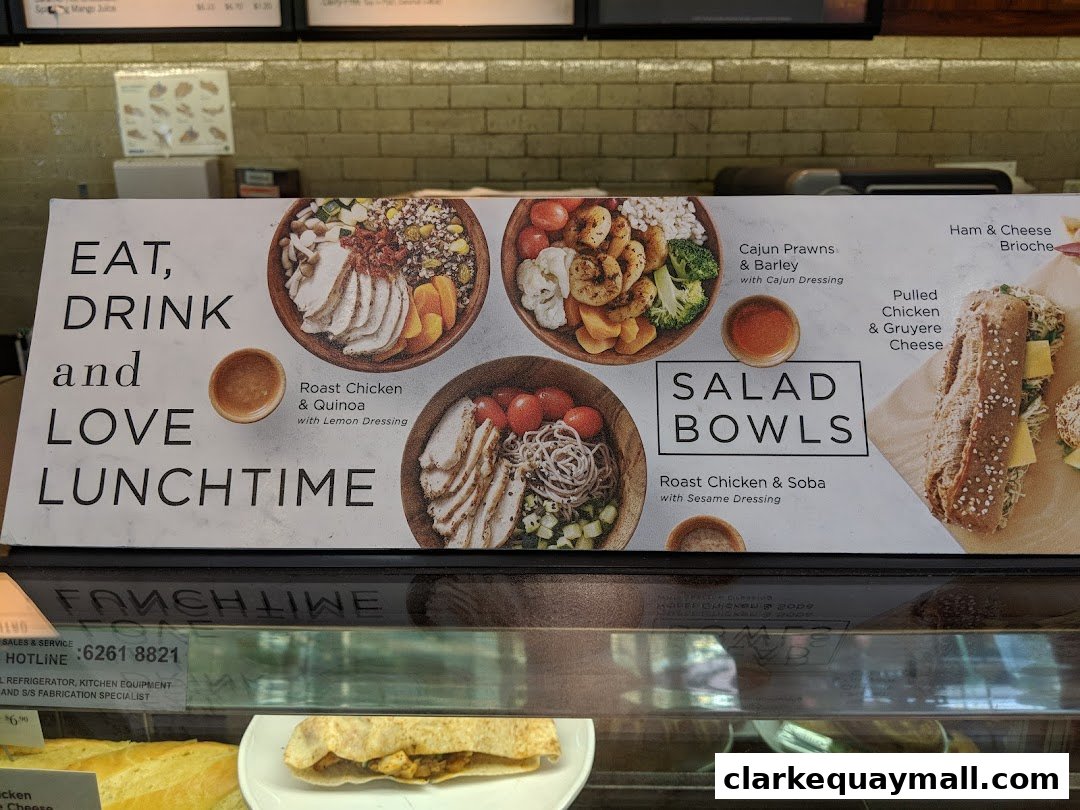 A sign advertising salad bowls and a sandwich with appetizing food photography.