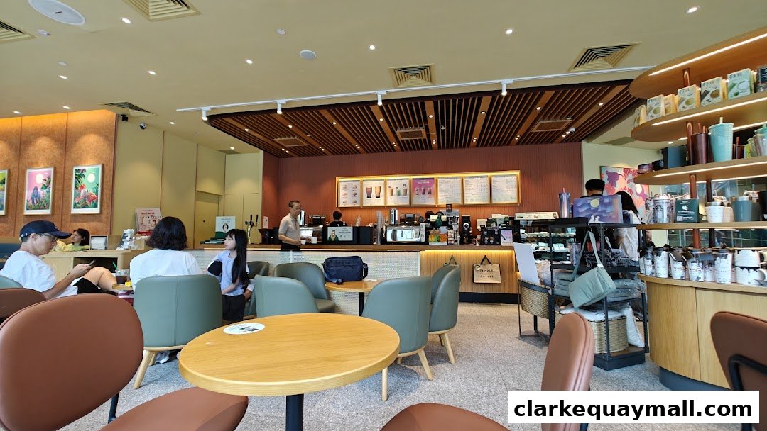Interior view of a Starbucks coffee shop with customers and staff at the counter.