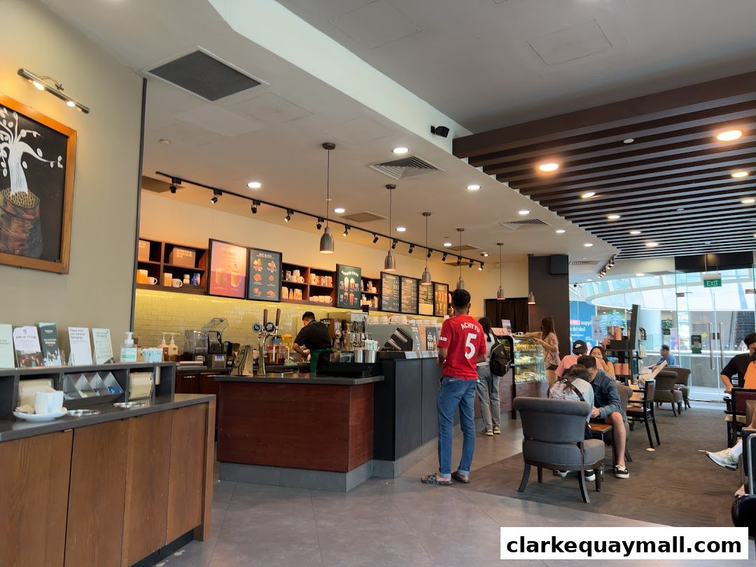 Interior view of a busy Starbucks cafe with customers and staff.