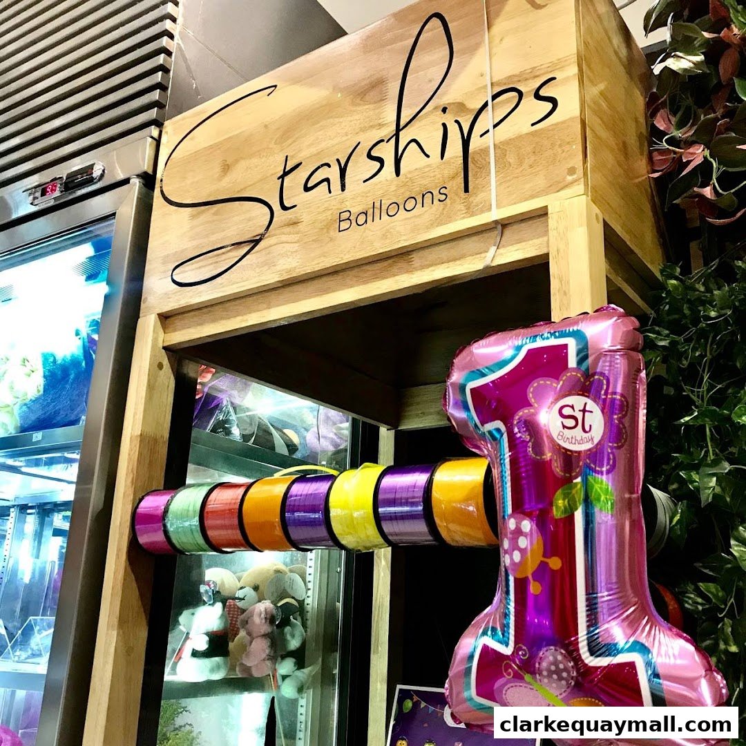 A display featuring colorful balloon ribbons and a large '1st Birthday' balloon.