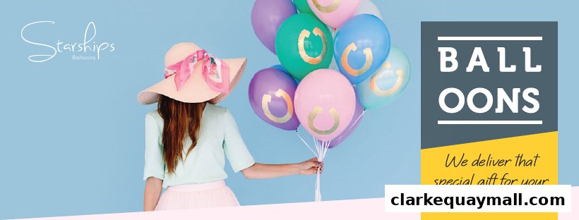 A person in a hat holds a bunch of colorful balloons with gold horseshoe designs.