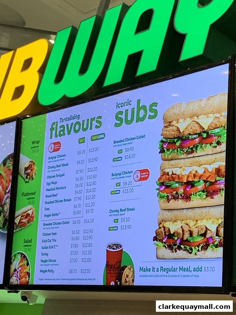 A digital menu board displaying various Subway sandwiches, wraps, and salads with prices.