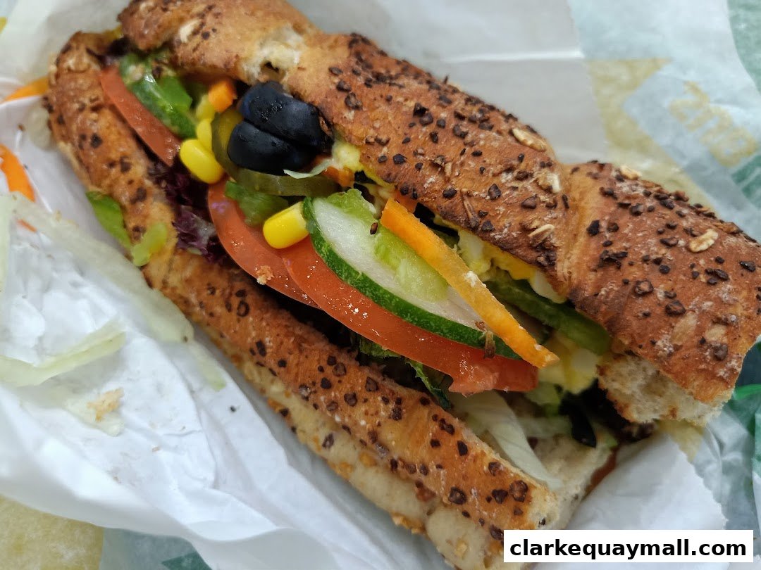 A close-up shot of a Subway sandwich with whole wheat bread and fresh vegetables.