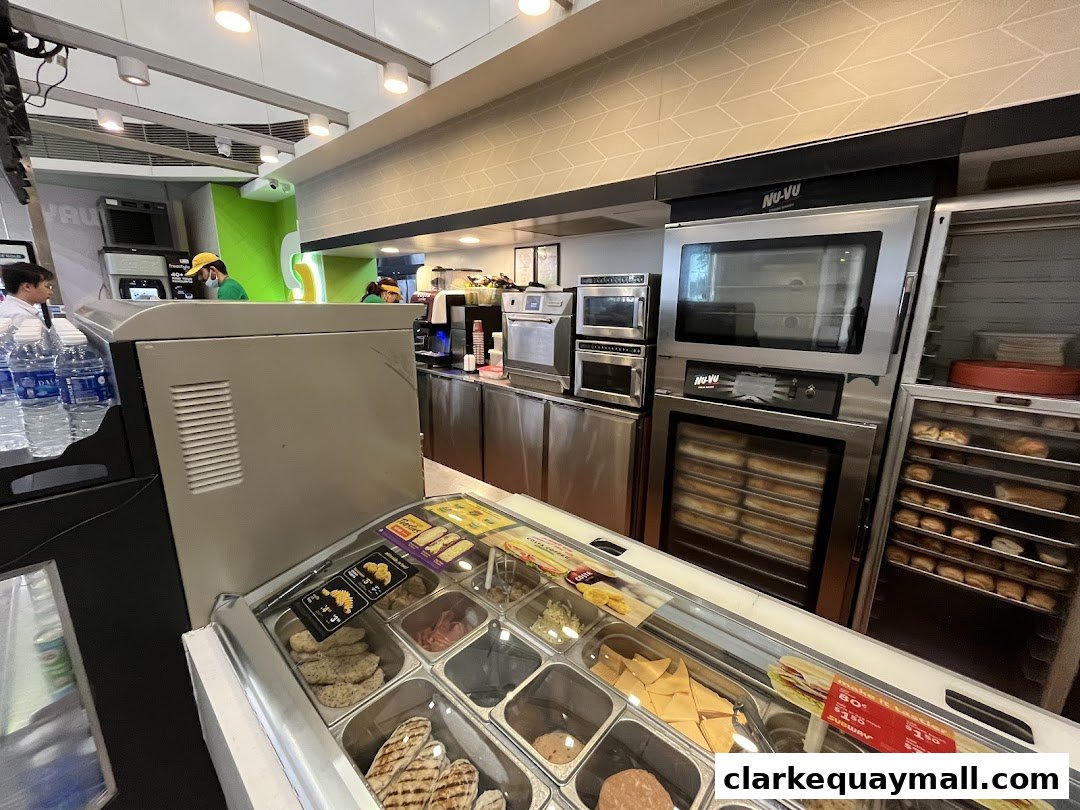 Interior view of a Subway restaurant showing food preparation area and ovens.