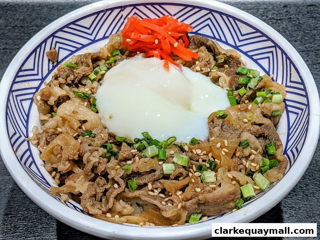 A close-up of a delicious beef bowl topped with a poached egg and pickled ginger.