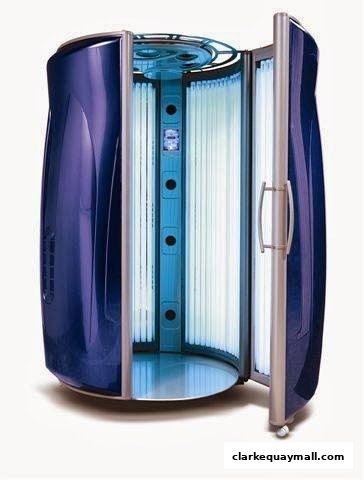 A modern, open tanning booth with blue interior and multiple UV lamps.