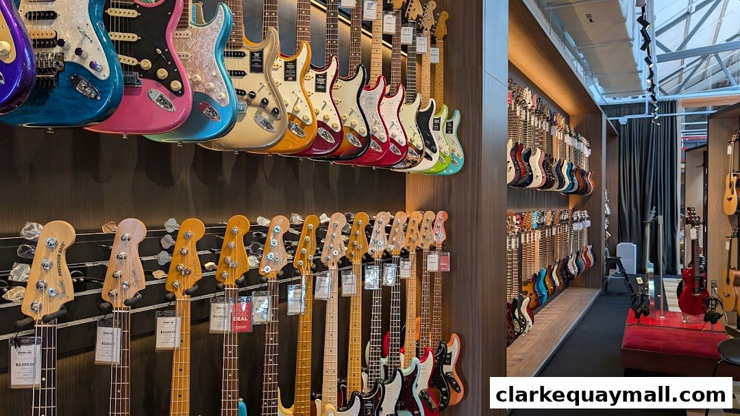 A wide selection of electric guitars and bass guitars displayed on walls and racks inside a music store.