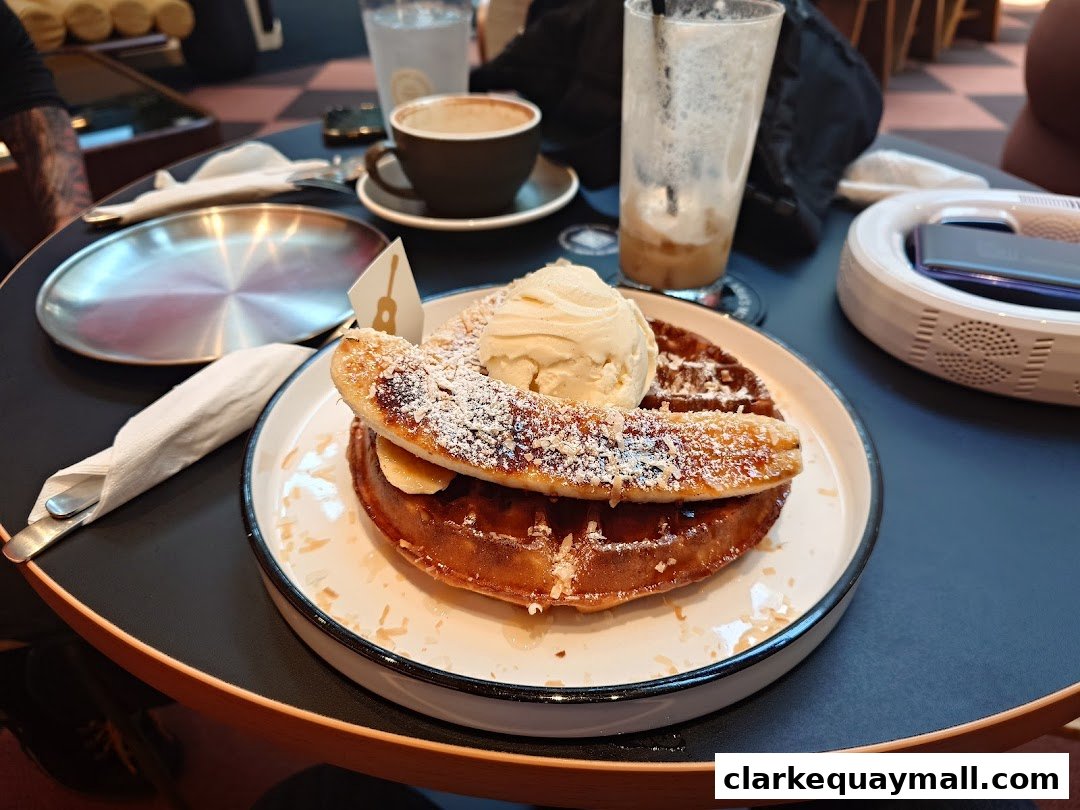 A delicious waffle topped with ice cream and banana slices, served with a drink.