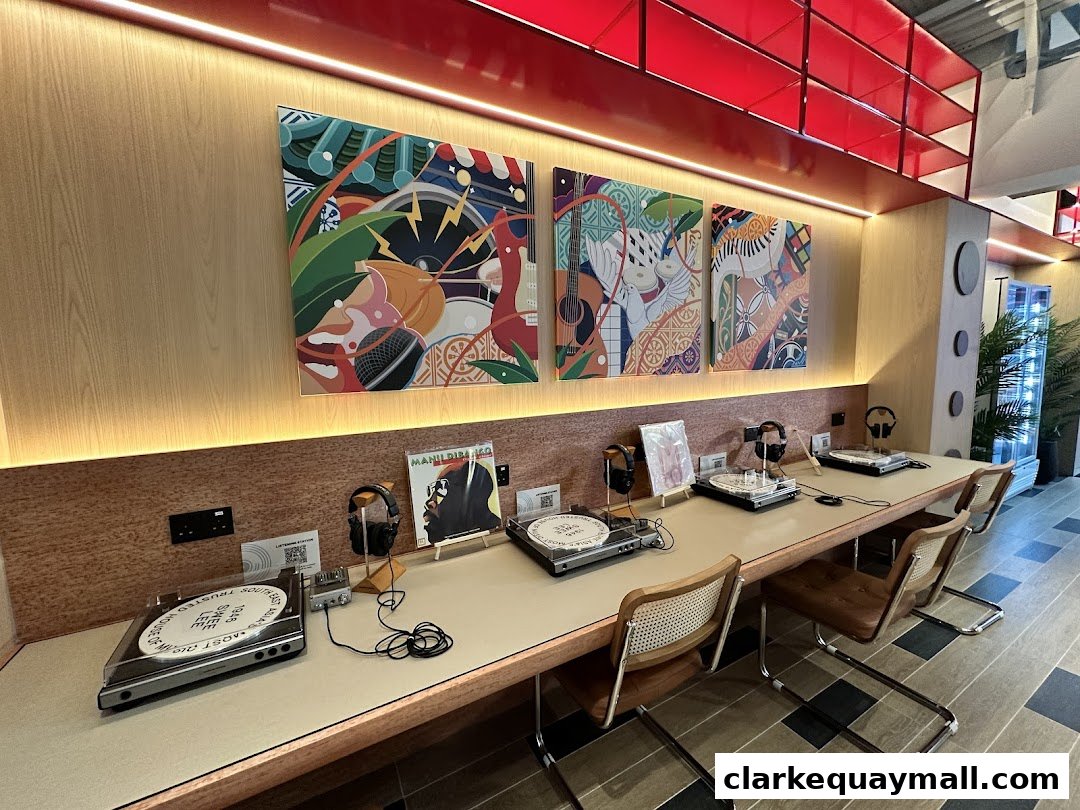 A listening station with turntables, headphones, and vinyl records, decorated with vibrant artwork.