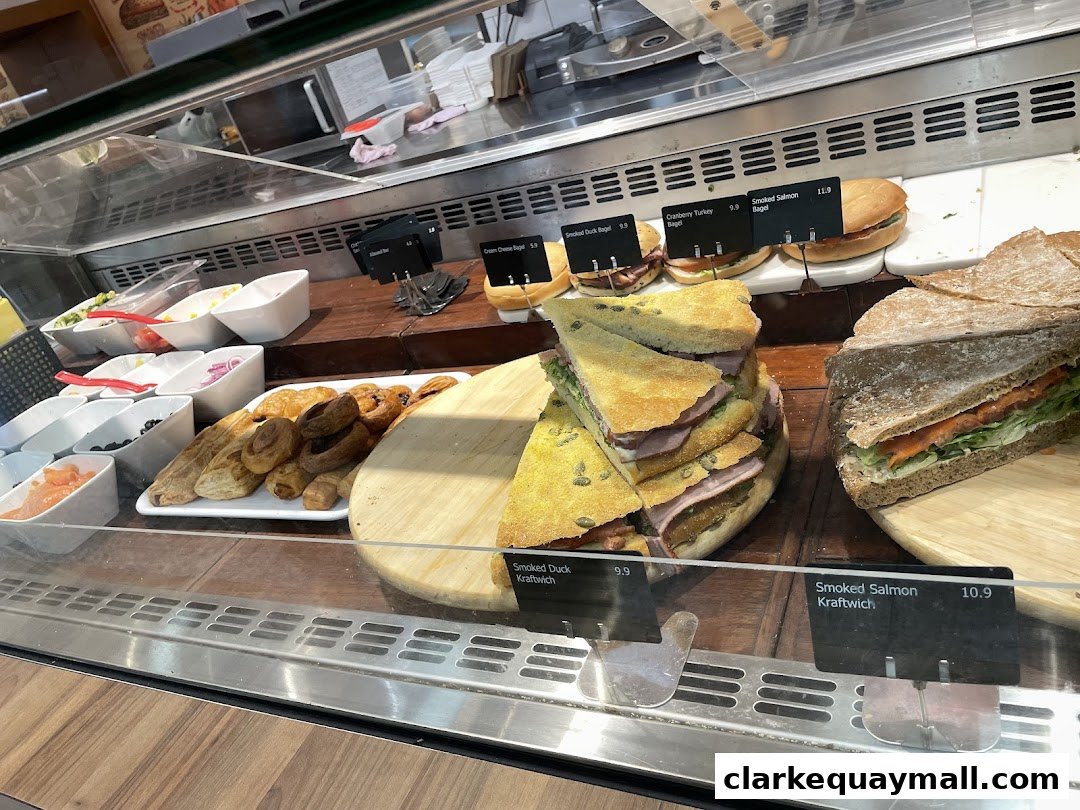 A display case filled with fresh sandwiches, bagels, and pastries at Swissbake Cafe.