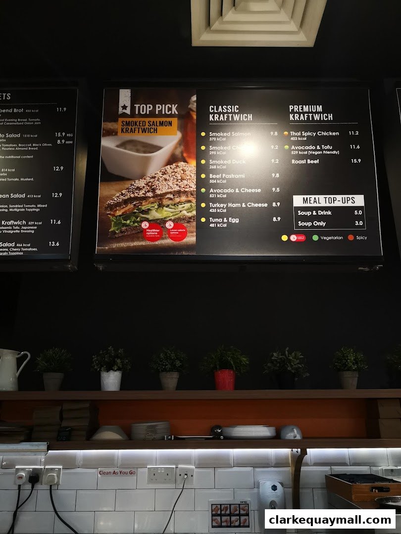 A digital menu board displaying various Kraftwich options and meal top-ups.