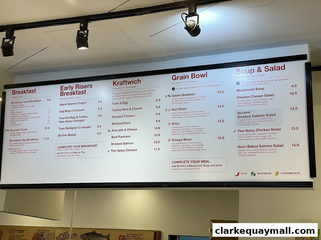 A menu board displaying breakfast, Kraftwich sandwiches, grain bowls, and soups & salads.