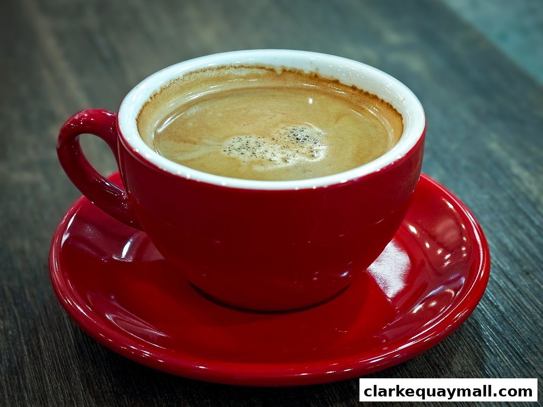 A close-up shot of a steaming cup of coffee in a red mug on a saucer.