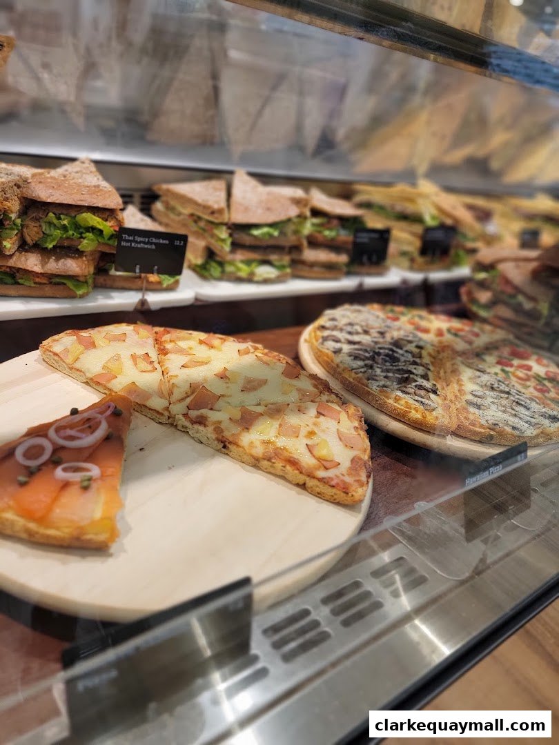 A display case filled with various sandwiches and pizzas, showcasing fresh ingredients.