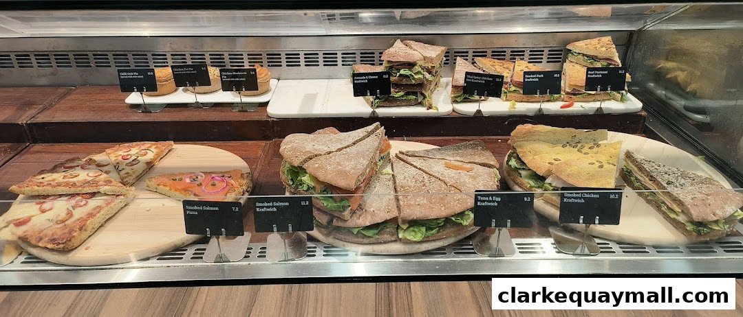 A display case filled with various sandwiches, pizzas, and pies from Swissbake Cafe.