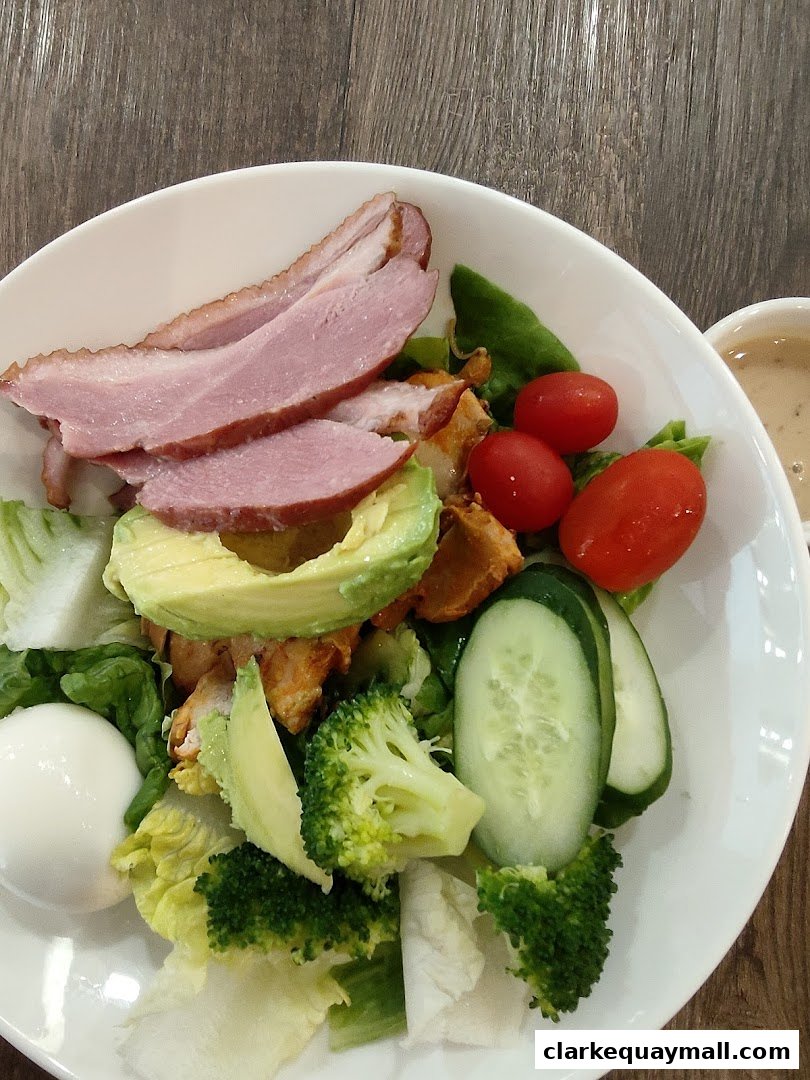 A delicious and healthy salad with smoked duck, avocado, egg, broccoli, and tomatoes.