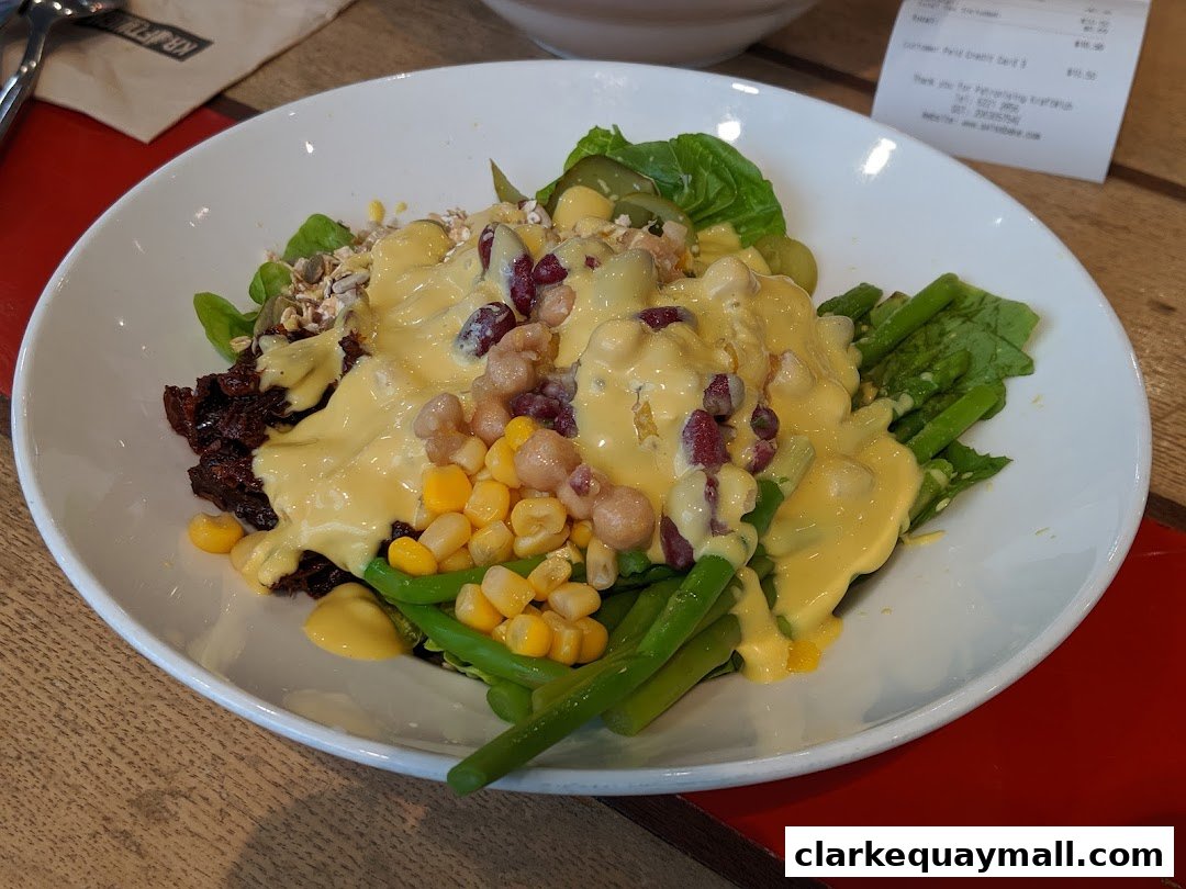 A vibrant salad with a creamy dressing, featuring beans, corn, and greens.