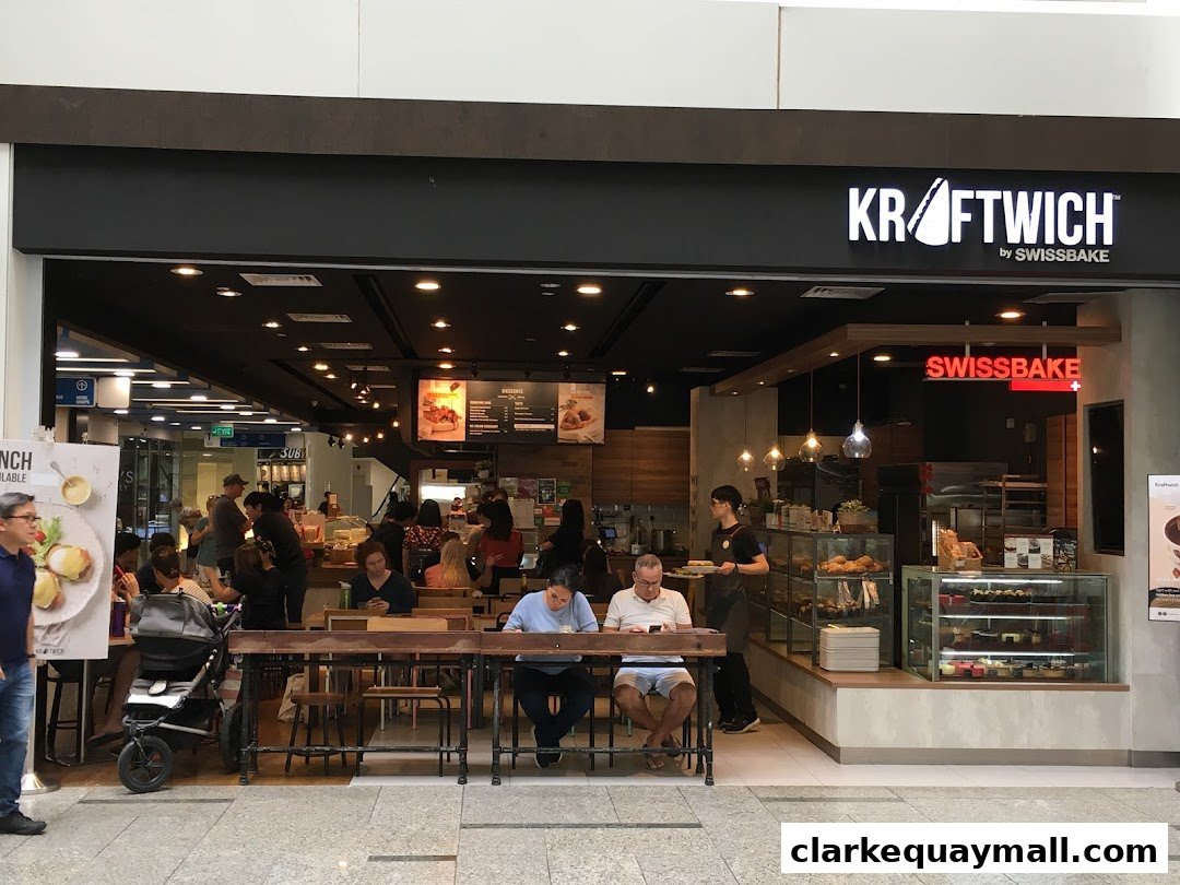 A busy Swissbake Cafe with customers dining and staff serving.